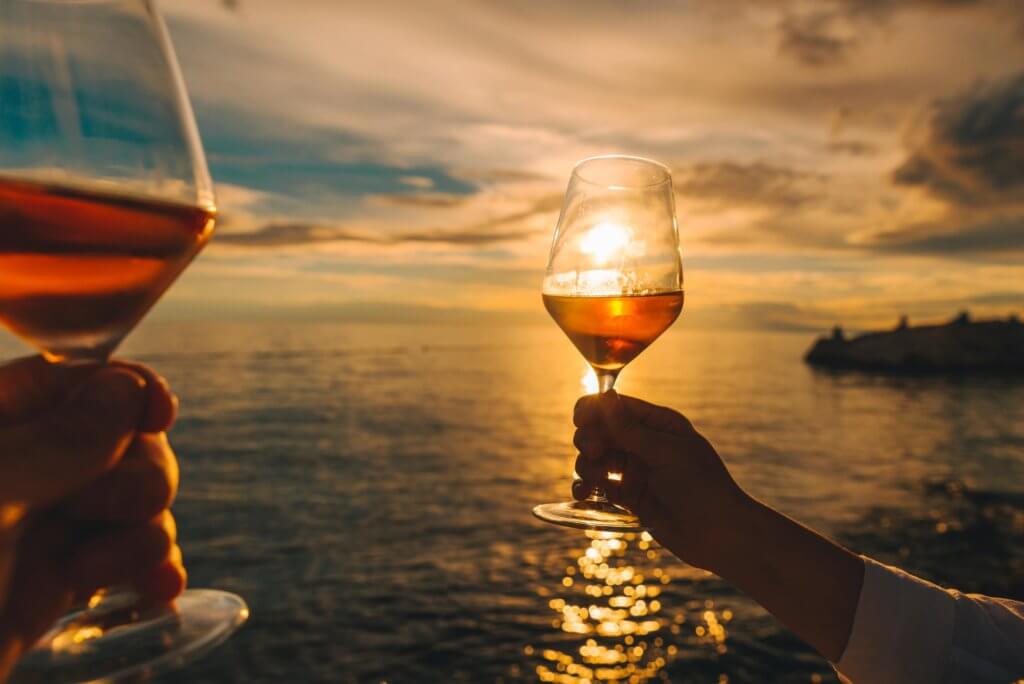 couple-resting-sunset-sea-beach-drinking-wine (1)